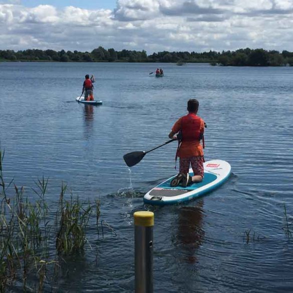 Two boys setting off across Cotswold Water Park Lake