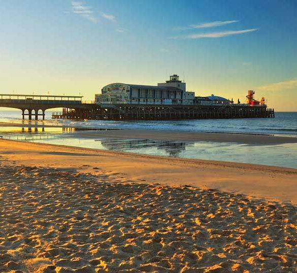 View of Bournemouth pier at sunset from beach, Dorset, England