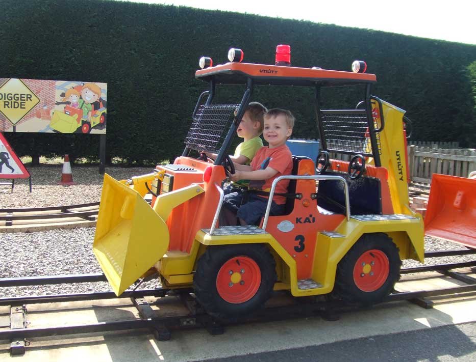 Fun at Paultons Park, Hampshire Two young boys on a digger, one of the rides at Peppa Pig world, Paultons Park, New Forest, Hampshire