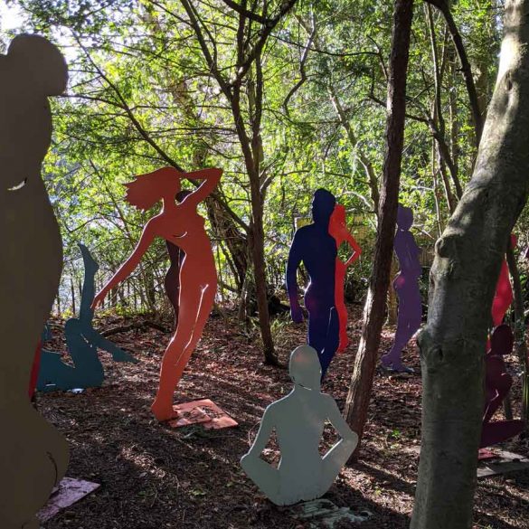 Outlines of bodies standing in woods sculpture