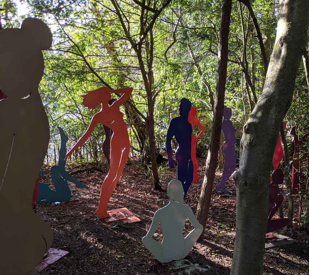 Outlines of bodies standing in woods sculpture