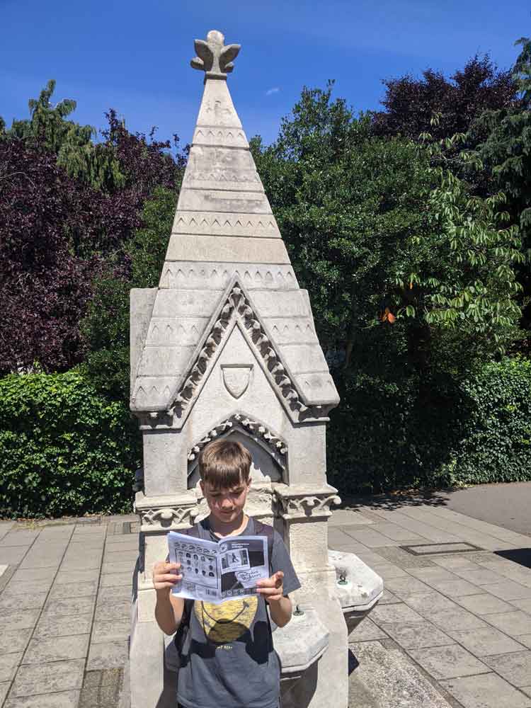 Boy looking at clues for Treasure Trail, Wimbledon, London, UK