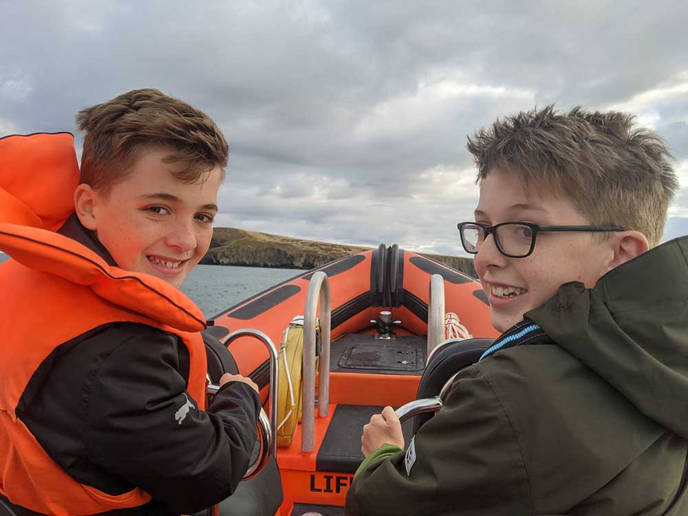 Two boys at front of boat on dolphin watching trip