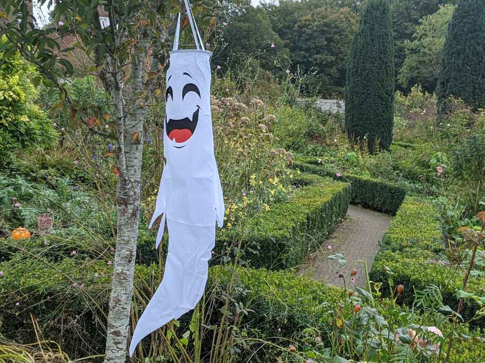 A smiley ghost hanging from a tree in the garden