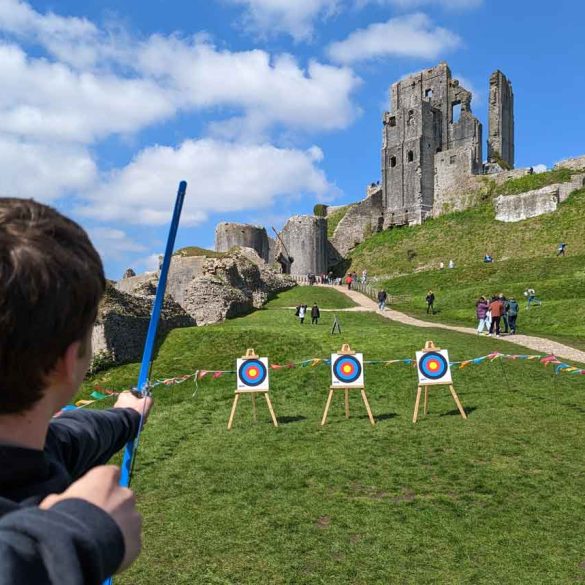 Young boy tries Archery at Corfe Castle, Dorset, UK