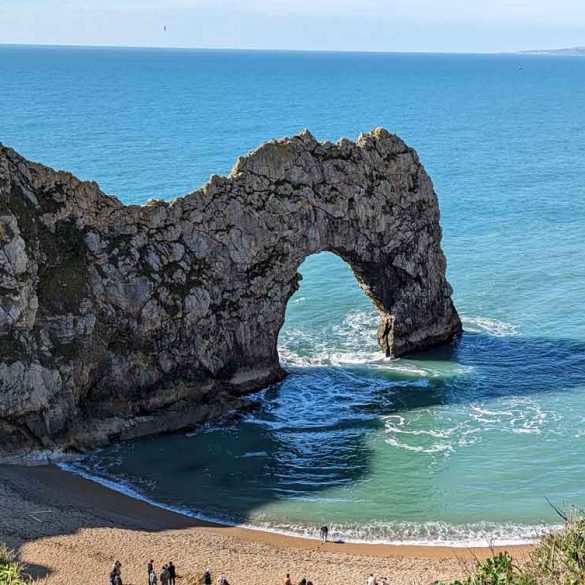 Blue sky and seat and the impressive cliff archway at Durdle Door, Dorset, UK