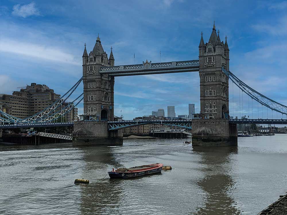 View of Tower Bridge with boat moored in foreground, London, UK