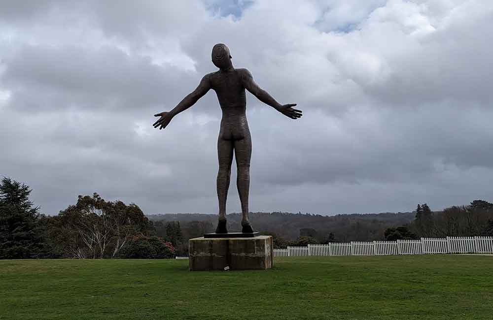 Giant Sculpture of a man with his hands held out at Leonardslee Gardens, West Sussex