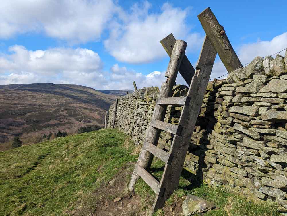 Stile over stone wall on the route to Alport Castle