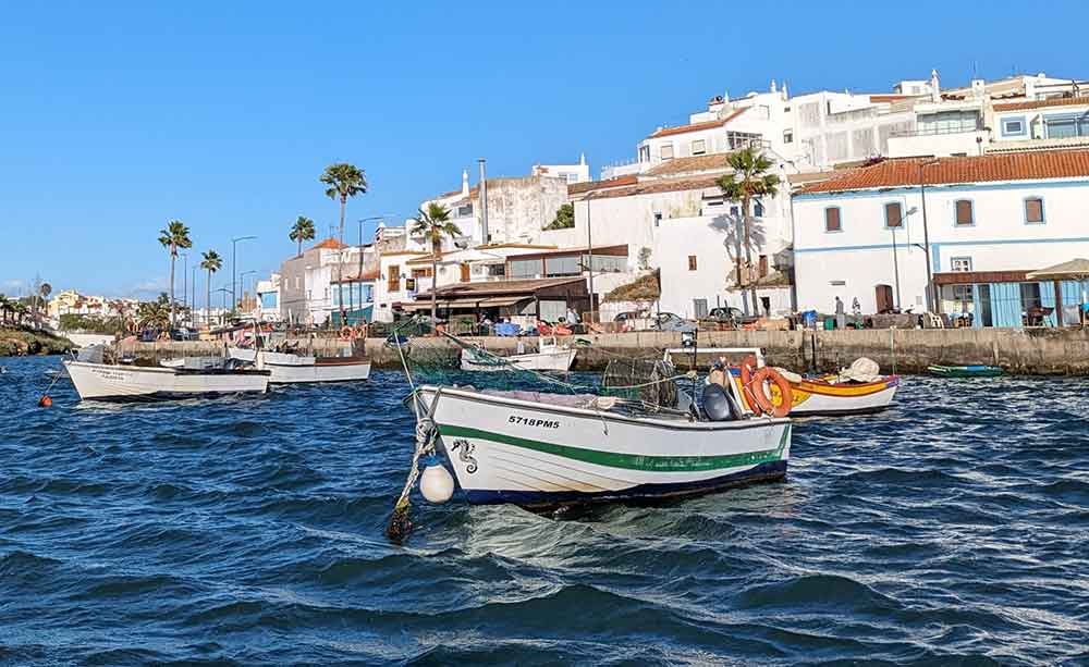 Boats moored in front of white washed houses at Marina da Portimao, Portugal