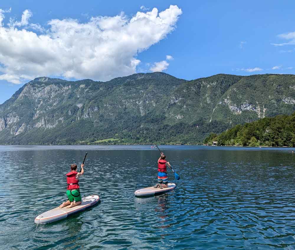 Boys on stand up paddleboard, Lake Bohinj