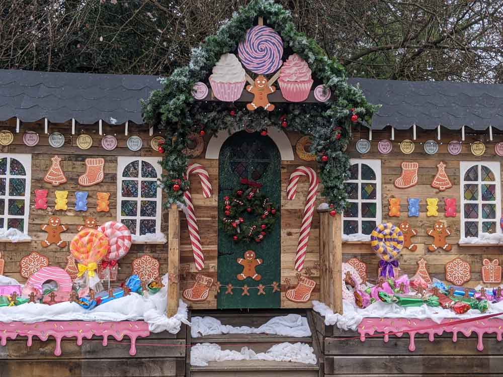 Cabin dressed as a gingerbread house, with artificial snow and candy sticks