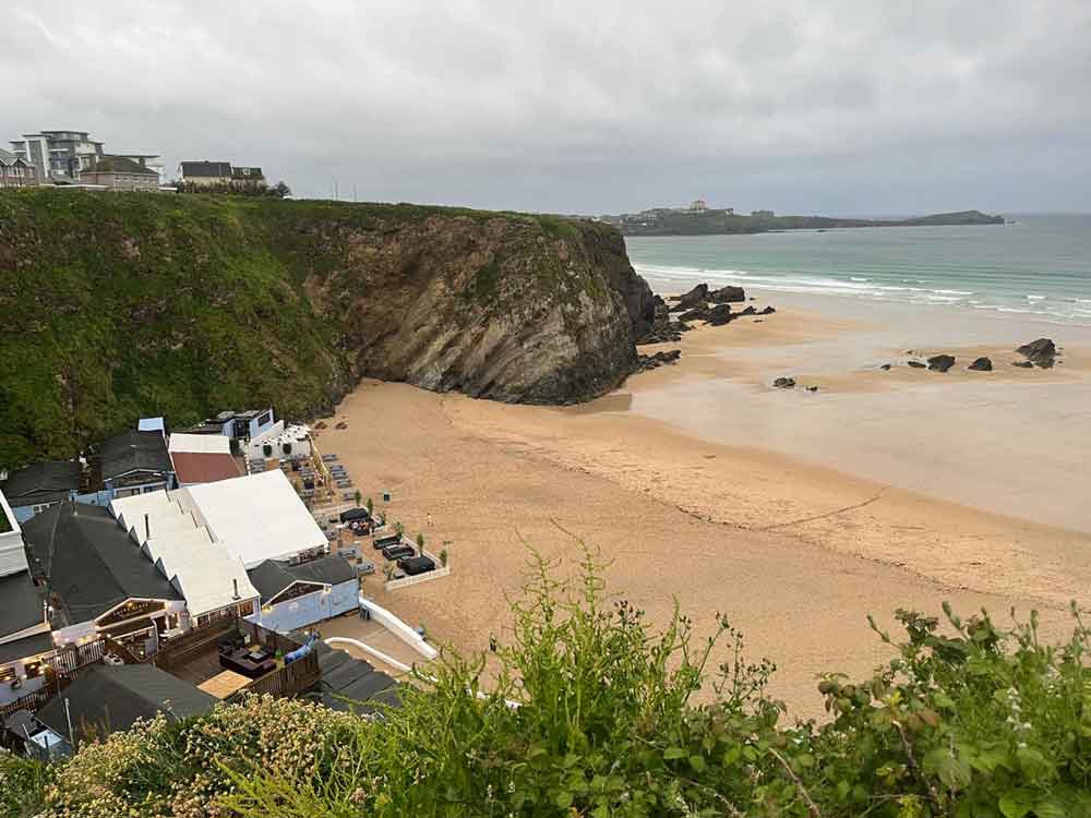 Views of sandy beach, cliff tops and beach huts