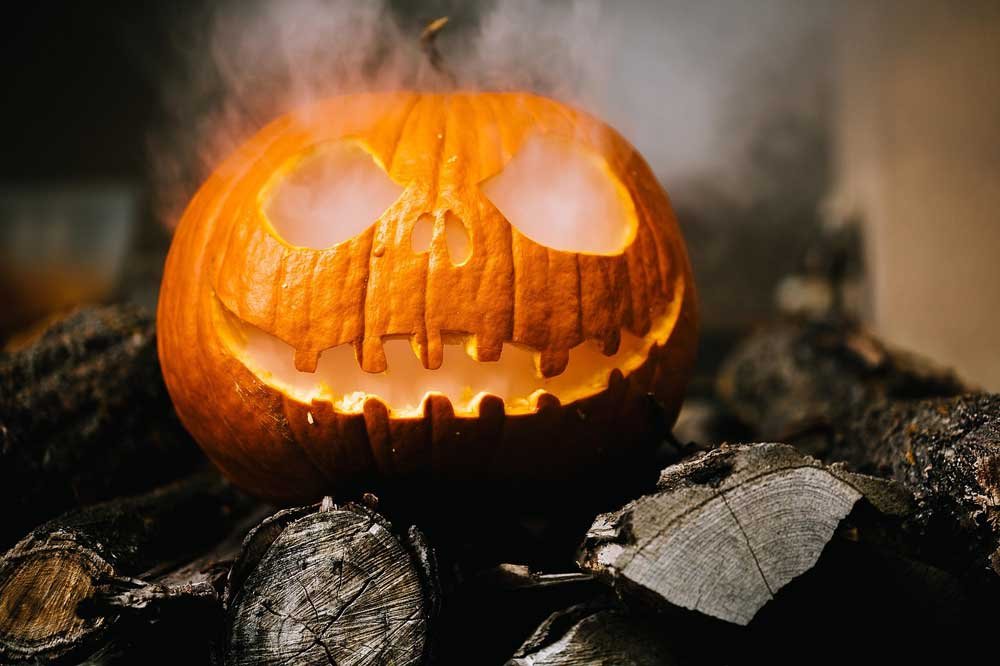 Halloween - smoking pumpkin on burnt wood