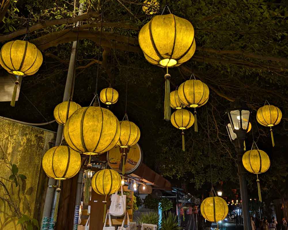 Lanterns in Hoi An, Vietnam Yellow lanterns hanging from trees at night in Hoi An