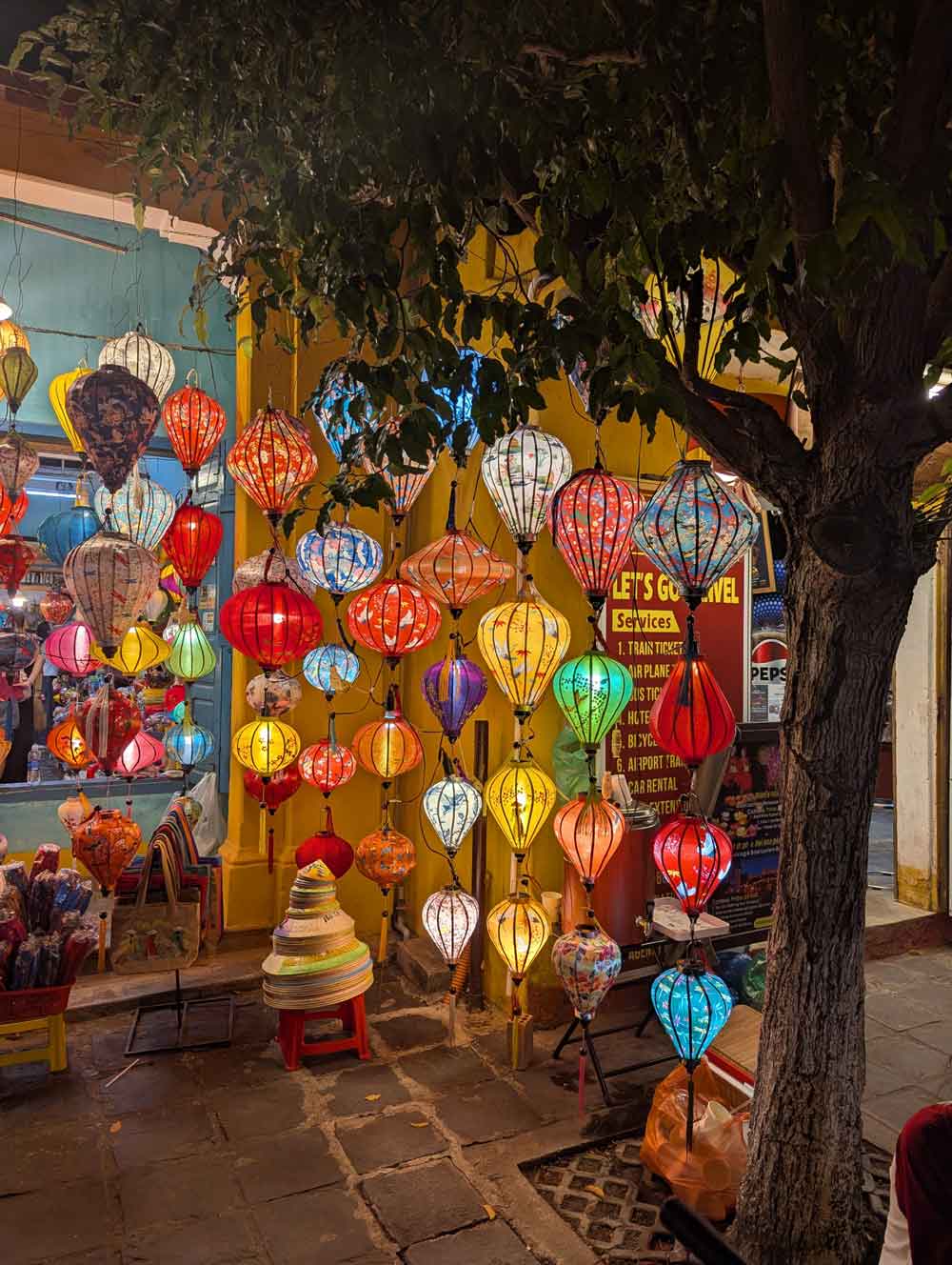 Lanterns outside shop in Hoi An, Vietnam Coloured lanterns hanging from a tree in front of a shop in Hoi An