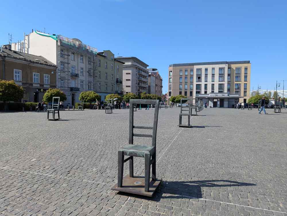 Iron chairs (statues) in large square, standing as memorial to Jewish community