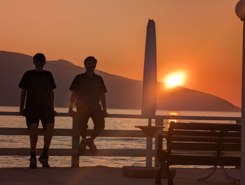 2 boys with orange sunset in background