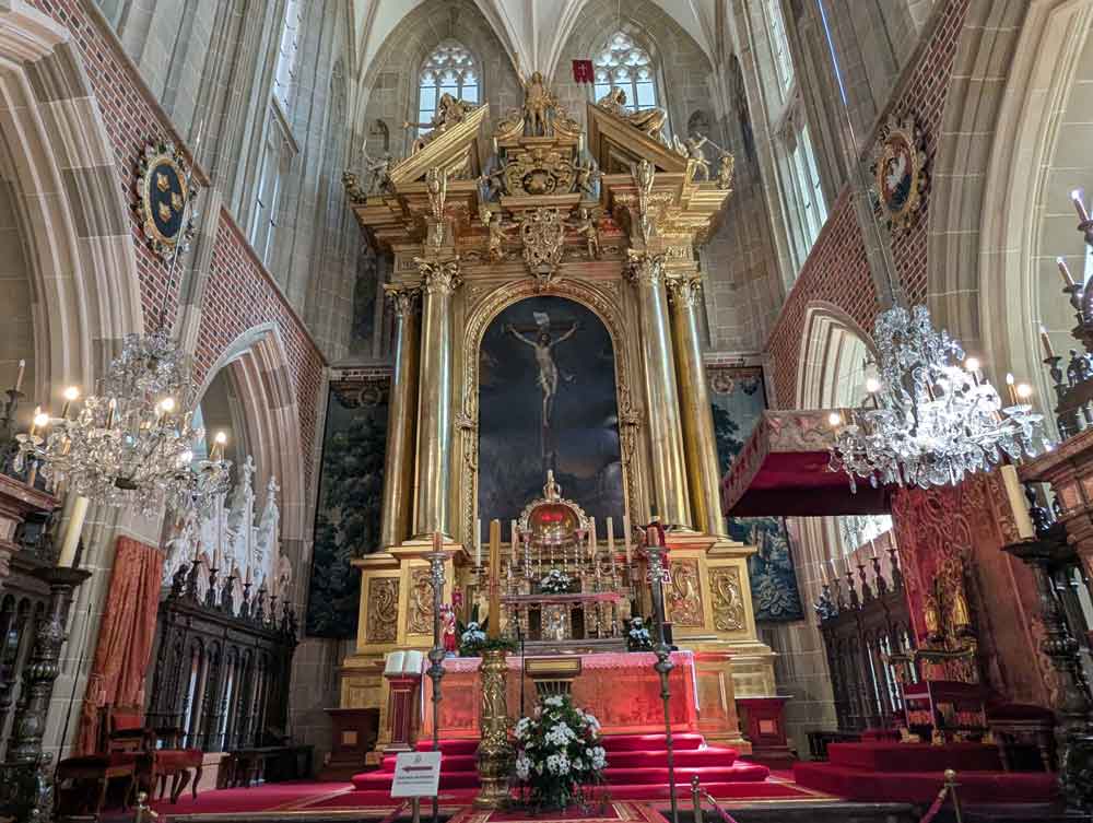 Red carpet leading to magnificent golden alter with chandeliers in forefront