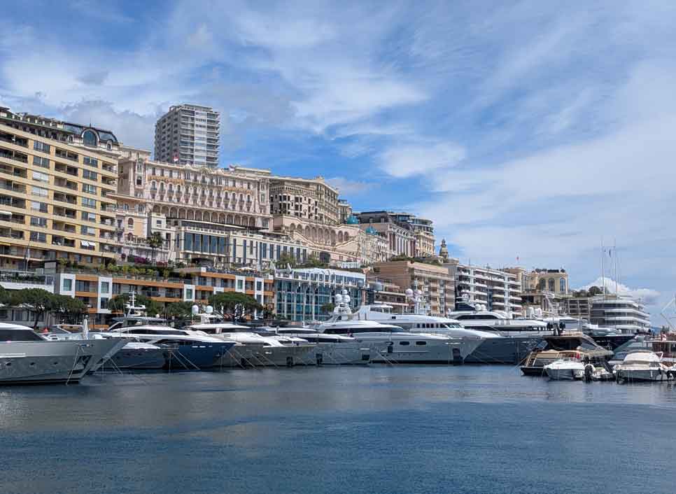 Row of mega yachts in the harbour in front of residential apartments in Moncao
