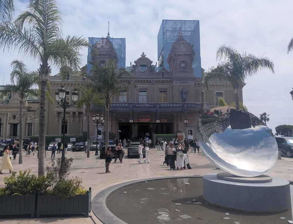 Casino de Monte-Carlo in Monaco, with palm trees and people in foreground