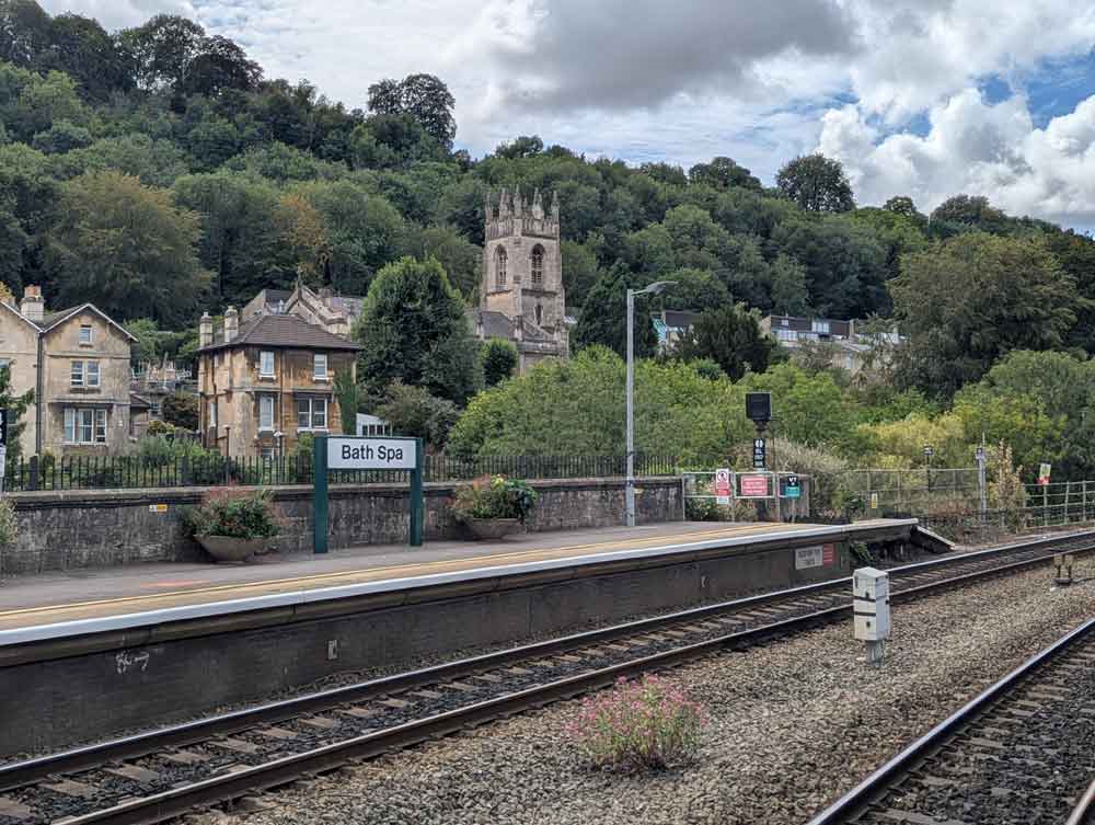 Railway station with church and trees in background
