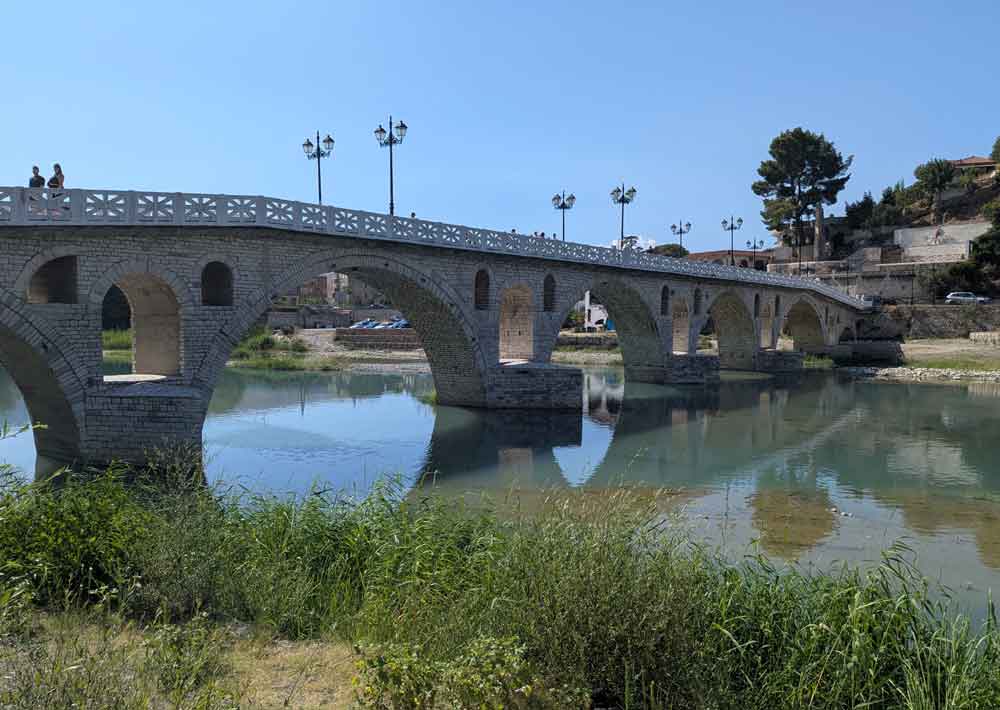 Stone bridge across calm river in Berat, Albania