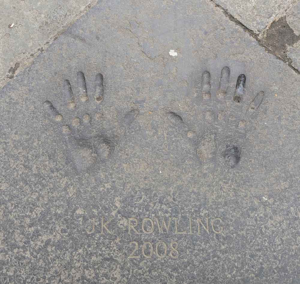 Handprints on a paving stone with an engraving of J.K Rowling underneath
